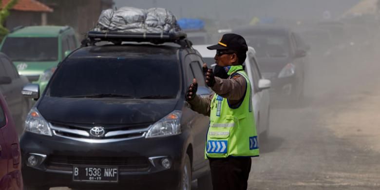 Polisi mengatur lalu lintas saat terjadi kemacetan di ruas Tol Pejagan-Brebes, Jawa Tengah, saat arus mudik H-6 menjelang Lebaran, Sabtu (11/7/2015). Tol Pejagan-Brebes dioperasikan untuk mengurangi kemacetan arus mudik Lebaran Idul Fitri 1436 H meski kondisi fisik jalan masih kurang baik.