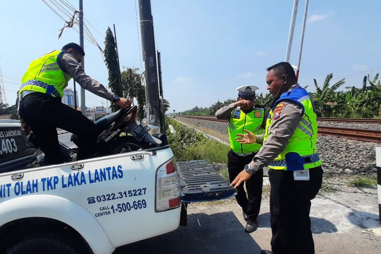 Polisi saat melakukan evakuasi sepeda motor yang tertabrak kereta api komuter di jalur perlintasan Desa Plosowahyu, Kecamatan/Kabupaten Lamongan, Jawa Timur, Rabu (9/8/2023).