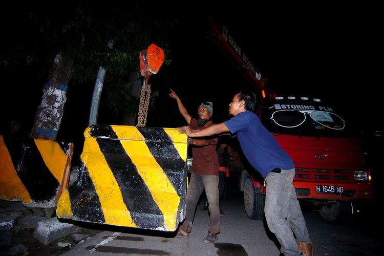 Pekerja memindahkan beton untuk diangkut saat pembukaan jalur utama karantina wilayah di Jalan Sultan Agung, Tegal, Jawa Tengah, Kamis (2/4/2020). Pemerintah Kota Tegal membuka kembali lima jalur utama masuk ke Kota Tegal pasca karantina wilayah sementara 31 jalur lainnya masih ditutup. ANTARA FOTO/Oky Lukmansyah/foc.