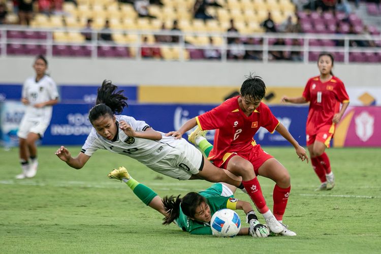 Pesepak bola Timnas Putri U16 Indonesia Nafeeza Ayasha Nori (kiri) berebut bola dengan pesepak bola Timnas Putri Vietnam Duong Phuong Nghi Nguyen (kanan) dan penjaga gawang Thi Cam My Tran (bawah) pada pertandingan perebutan peringkat ketiga Piala AFF Putri U16 di Stadion Manahan, Solo, Jawa Tengah, Jumat (29/8/2025). Timnas putri U16 dikalahkan Timnas putri Vietnam melalui adu penalti. ANTARA FOTO/Mohammad Ayudha/rwa.