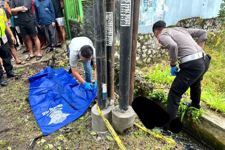 Petugas Unit Gakkum Satlantas dan Inafis Polres Blitar Kota hendak memindahkan jasad seorang pria dari selokan Jalan Kenari, Kota Blitar, Minggu (15/12/2024) pagi