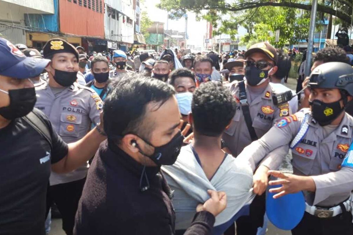 Aparat kepolisian menangkap sejumlah mahasiswa saat aksi unjuk rasa menolak penerapan pembatasan kegiatan masyarakat (PPKM) di depan kantor Wali Kota Ambon berujung bentrok, Jumat (16/7/2021)