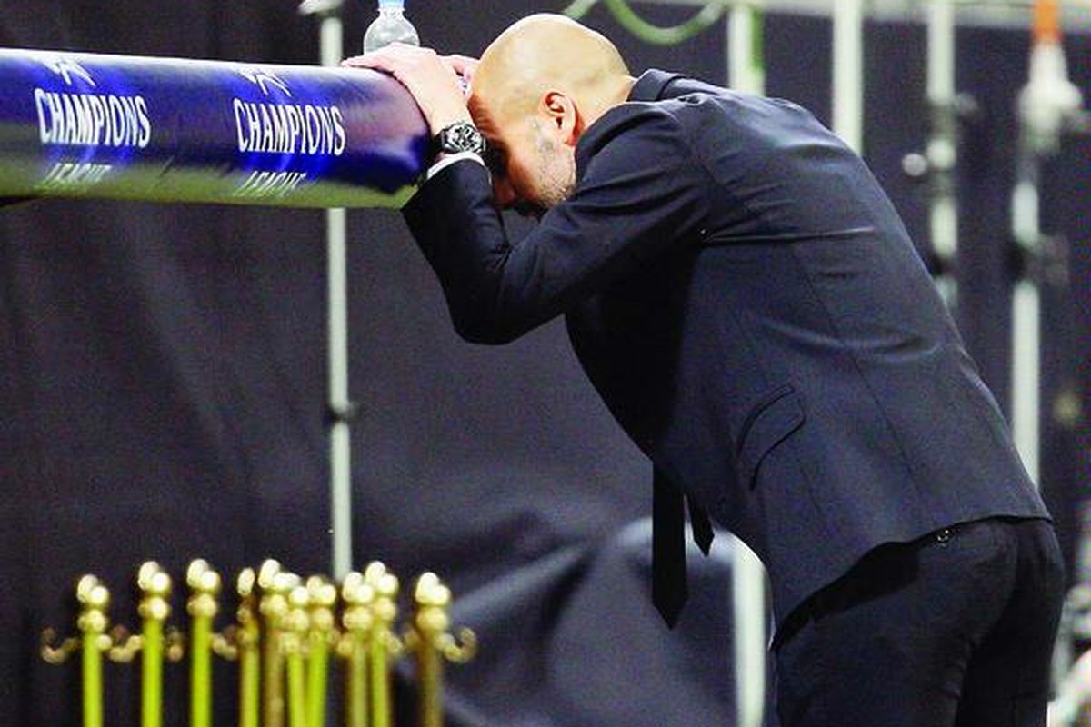 Pelatih Barcelona Josep Guardiola tampak kecewa dengan menyandarkan kepalanya ke kursi pemain cadangan setelah pemainnya gagal mencetak gol. Pada putaran pertama perempat final Liga Champions ini, Barcelona menahan imbang AC Milan di Stadion San Siro, Milan, Italia, Rabu (28/3). 