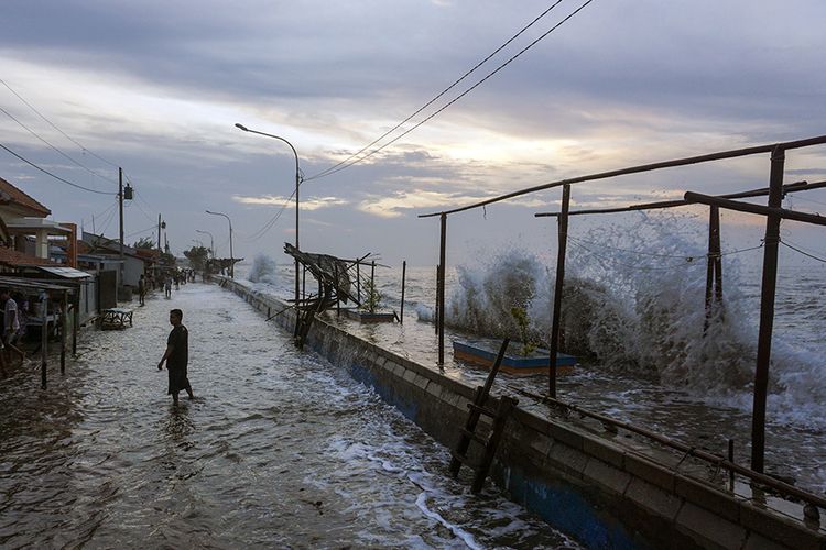 Warga beraktivitas di sekitar terpaan gelombang laut pesisir Pantai Utara di Pekalongan, Jawa Tengah, Senin (1/6/2020). Palang Merah Indonesia (PMI) Kota Pekalongan menghimbau kepada warga sekitar pantai untuk waspada terhadap gelombang laut dengan ketinggian sekitar 1-3 meter akibat adanya angin kencang dari laut menuju darat.