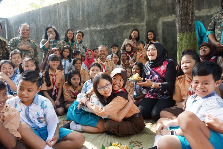 BERPELUKAN—Siswi muslim SDN 01 Nambangan Lor Kota Madiun menyampaikan selamat merayakan Natal sambil memeluk siswi SDK Santa Maria Kota Madiun. Sejumlah siswa dan siswi muslim SDN 01 Nambangan Lor Kota Madiun mendatangi SDK Santa Maria memberikan tumpeng dan memberikan ucapan selamat natal.