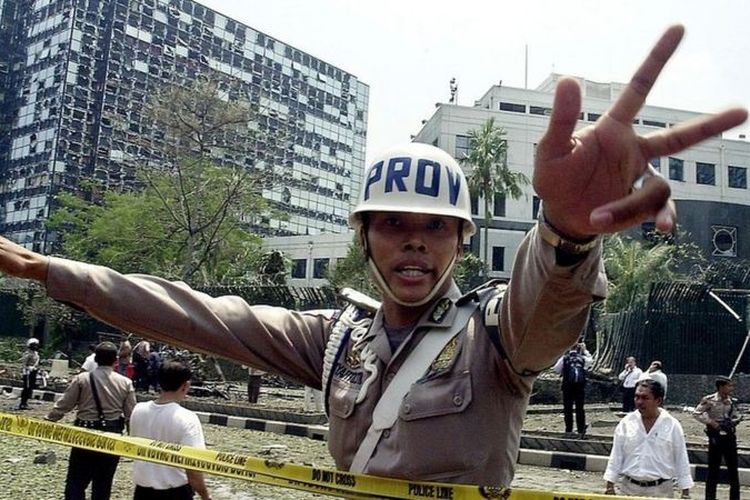 Seorang anggota polisi mengamankan situasi setelah bom meledak di depan Kedubes Australia di Jakarta, 9 September 2004.