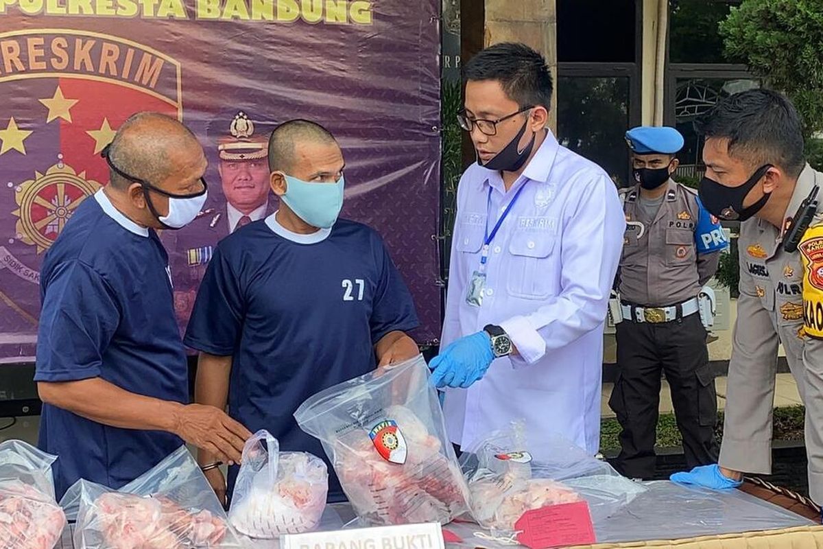 Anggota kepolisian tengah memperlihatkan barang bukti daging babi yang dijual sebagai daging sapi di wilayah Kabupaten Bandung.