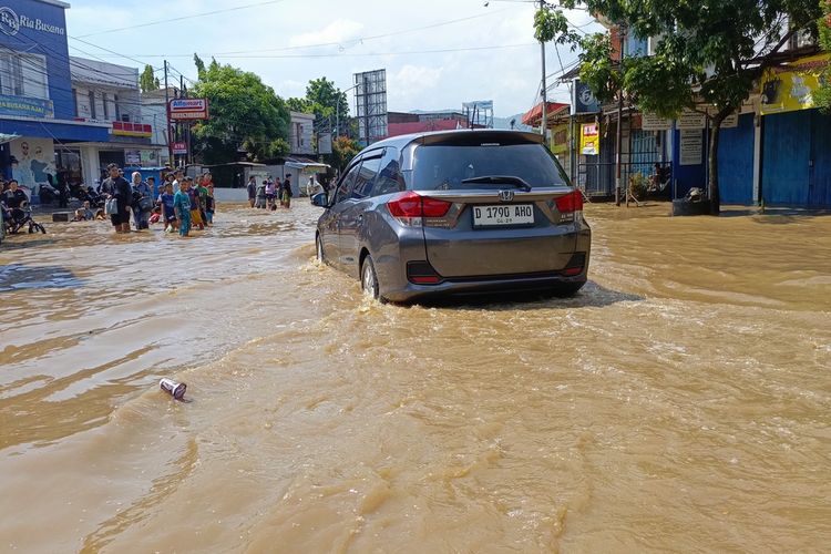 Arus lalu lintas di Jalan Raya Dayeuhkolot, Kabupaten Bandung, JawaBarat, tersendat lanataran luapan sungai Citarum, banjir tersebut terjadi sejak Jumat kemarin, jalur itu hanya bisa di lintasi oleh kendaraan besae, Sabtu (1/11/2025)