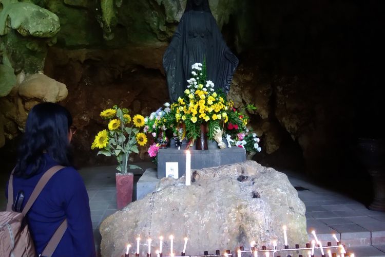 Pengunjung sedang berdoa di Patung Bunda Maria di Goa Maria Perantara Wahyu Tritis atau biasa dikenal Goa Maria Tritis yang terletak di Dusun Bulu, Desa Giring, Kecamatan Paliyan, Gunungkidul, DI Yogyakarta, Minggu (2/9/2018).