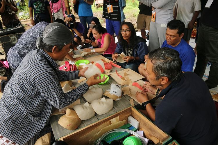 Maestro topeng Pono Wiguna atau Ki Supo memberi penjelasan tentang cara membuat topeng tari di area workshop Kulon Progo Festival di Bendung Khayangan, DI Yogyakarta, Sabtu (25/11/2017).