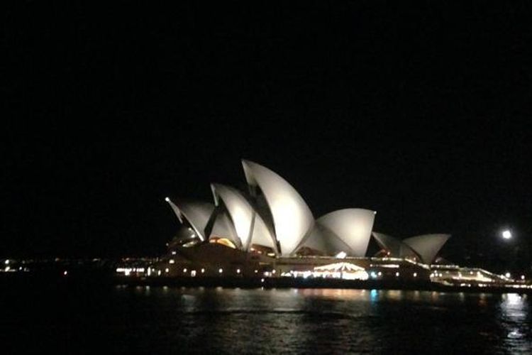 Saat matahari tenggelam, Kota Sydney pun berubah menjadi permadani yang bermandikan cahaya, termasuk bangunan Sydney Opera House