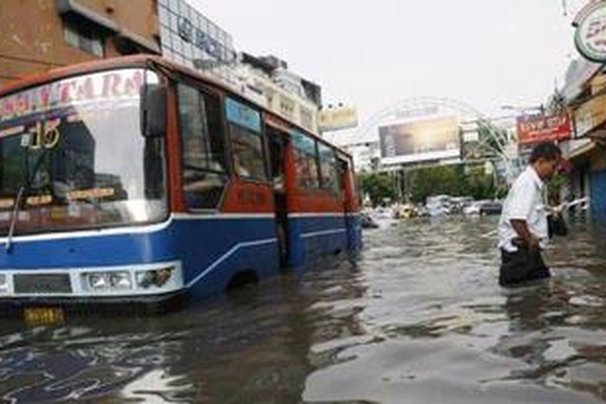 Seorang penumpang meninggalkan bus yang mogok akibat terjebak genangan air di Jalan H Agus Salim, Jakarta Pusat, Kamis (12/11/2009). Hujan deras yang mengguyur Jakarta dan sekitarnya mengkibatkan sejumlah daerah tergenang. Kondisi tersebut berdampak pada kemacetan lalu lintas.