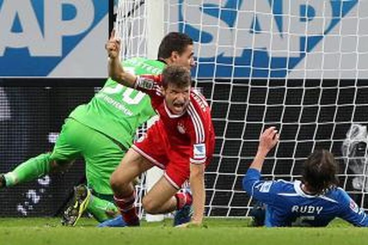 Gelandang Bayern Muenchen, Thomas Mueller (tengah) merayakan gol yang dicetak untuk membuat timnya menang 2-1 atas Hoffenheim, Sabtu (2/11/2013) dalam laga Bundesliga. Tampak kiper Hoffenheim, Koen Casteels (kiri) dan gelandang Sebastian Rudy (kanan), harus kecewa karena gagal membendung Mueller.
