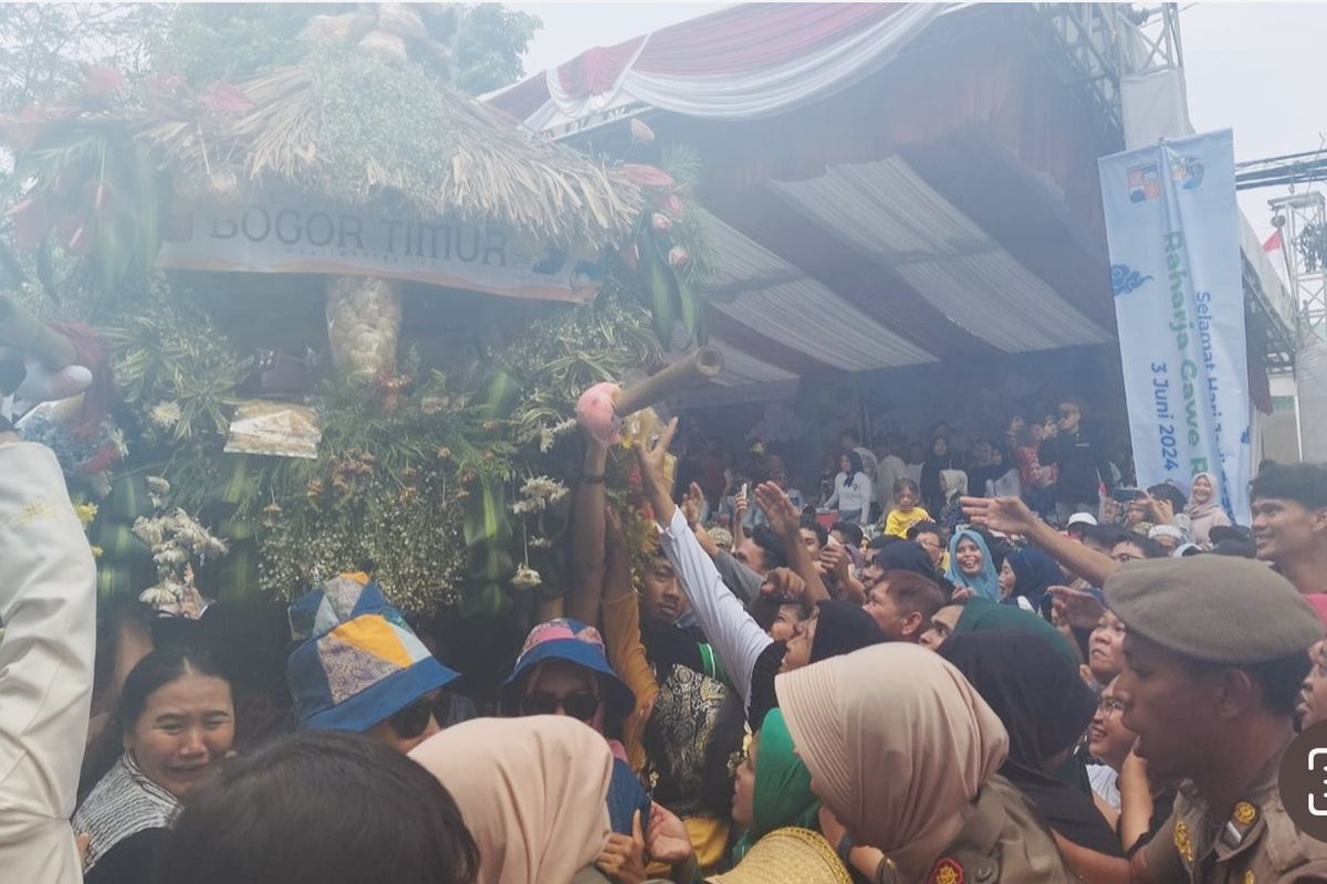 Warga berebut isi hasil bumi yang ditempatkan di dalam dongdang saat Helaran Hari Jadi Bogor ke-542 di Jalan Sudirman, Kota Bogor, Jawa Barat.