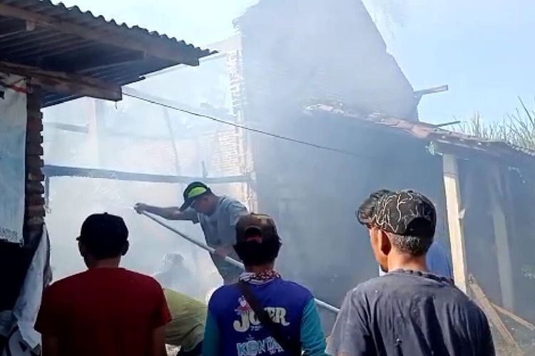 Warga berusaha memadamkan api yang membakar pabrik penggilingan kapuk di Desa Ngadri, Kecamatan Binangun, Kabupaten Blitar, Minggu (14/5/2023)