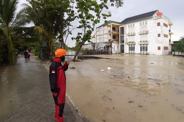 Petugas BPBD Gresik memantau debit air bah yang melanda sejumlah desa di Kecamatan Benjeng, Jumat (5/11/2021).