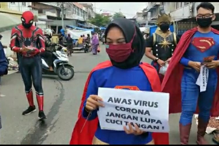 Pegawai Diskominfotik Riau yang mengenakan kostum superhero saat sosialisasi pencegahan Covid-19 di pasar tradisional di Kota Pekanbaru, Riau, Kamis (23/4/2020).