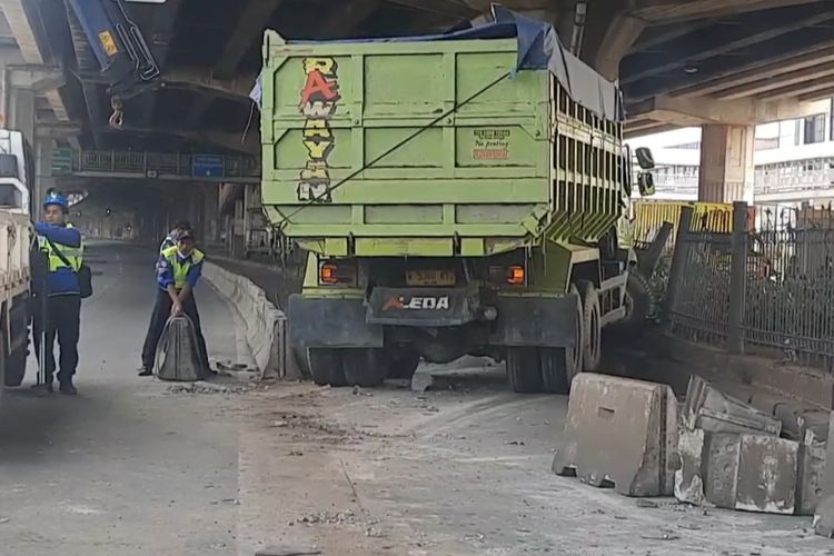 Sebuah truk bermuatan pasir mengalami kecelakaan dengan menghantam separator Transjakarta dan pagar pembatas jalur di Jalan DI Pandjaitan, Kecamatan Jatinegara, Jakarta Timur, Selasa (21/3/2023).