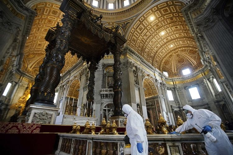 Para petugas disinfektan memakai pakaian pelindung sedang melakukan pembersihan di bawah kanopi perunggu patung Santo petrus Baldachin di dalam Basilika Santo Petrus di Vatikan, Jumat (15/5/2020).
