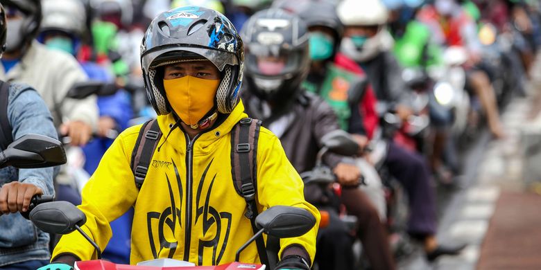 Warga menggunakan masker saat mengendarai sepeda motor di Jl. Letjen S. Parman, Jakarta Barat, Senin (4/5/2020). Provinsi DKI Jakarta memasuki pelaksanaan pembatasan sosial berskala besar (PSBB) yang diperpanjang ke tahap kedua. Tujuan PSBB ini adalah untuk menekan penyebaran virus corona (Covid-19).