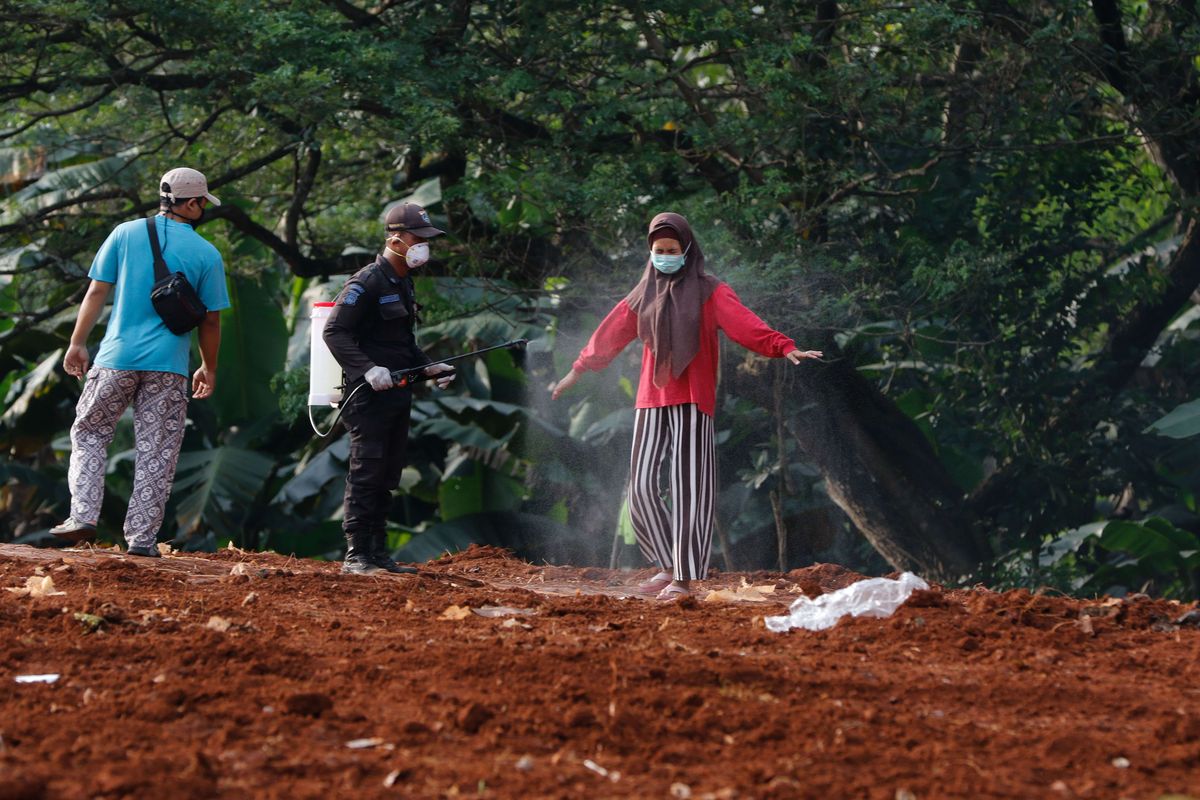 Petugas menyemprotkan disinfektan pada petugas pemakaman dan keluarga korban meninggal suspect virus corona atau Covid-19 di TPU Pondok Ranggon, Jakarta Timur, Jumat (3/4/2020). Hingga hari ini, total ada 1.986 kasus positif Covid-19 di Indonesia. Sebanyak 181 orang meninggal dan 134 orang sembuh.