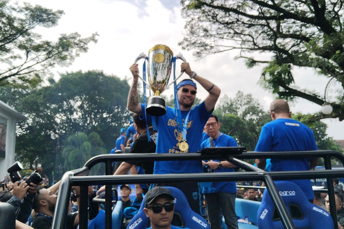 Gelandang Persib Bandung, Marc Klok, mengangkat piala Liga 1 musim 2024-2025 dalam arak-arakan dan pawai Juara Persib Bandung, Sabtu (25/5/2025).