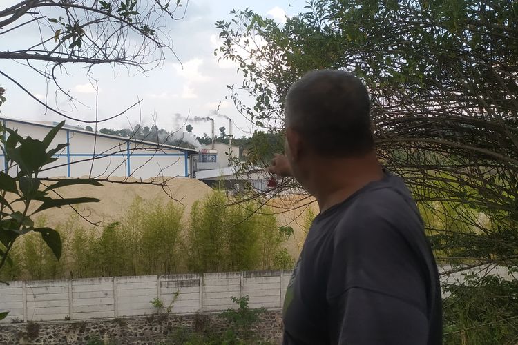 Salah satu warga memperlihatkan pabrik yang mengeluarkan plasap pekat di Kota Semarang, Jawa Tengah