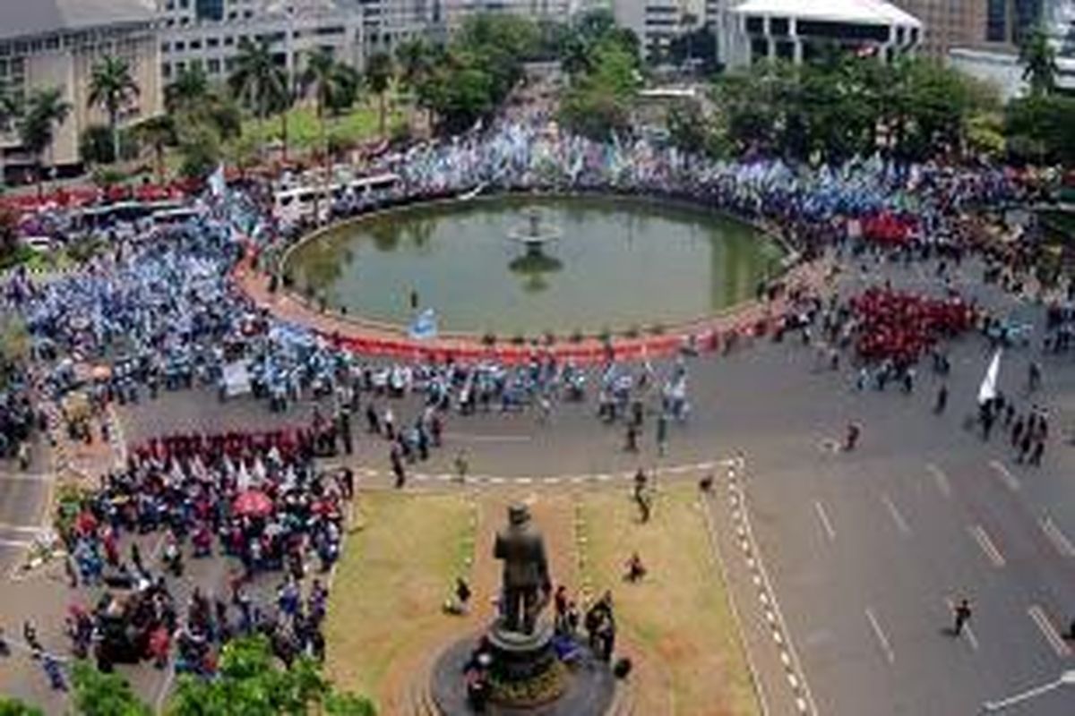 Buruh melakukan aksi unjuk rasa di Bundaran Patung Kuda, Jl MH Thamrin, Jakarta, Selasa (1/9/2015). Dalam aksi ini mereka menuntut pemerintah menurunkan harga sembako, menolak PHK akibat perlambatan ekonomi, hingga kenaikan upah pada 2016.