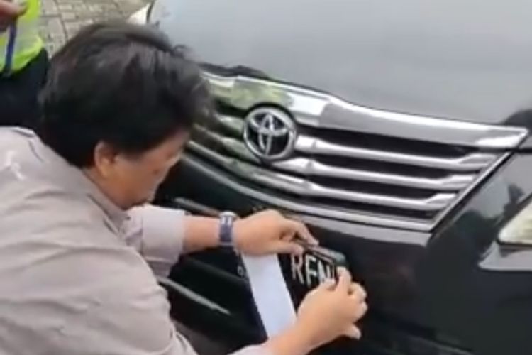 Pengendara mobil yang ditegur polisi karena menggunakan pelat nomor bodong di Cawang, Jakarta Timur, Senin (26/12/2022).