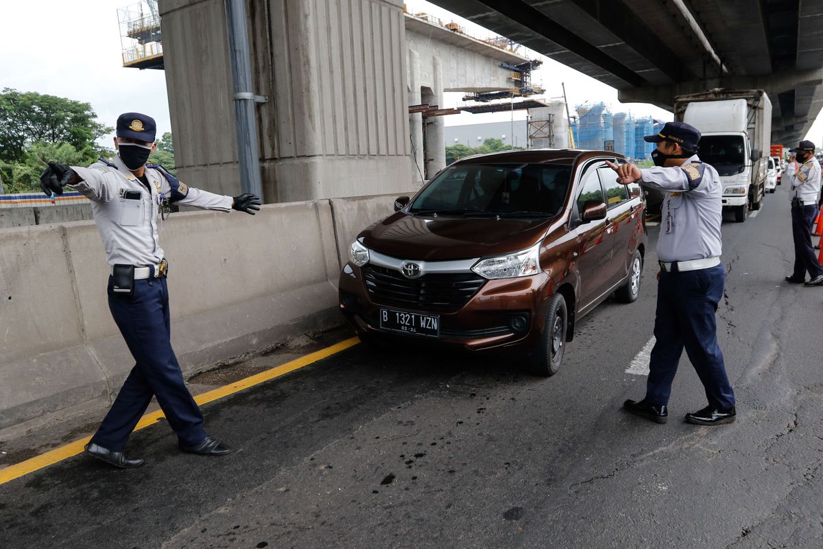 Petugas melakukan pemeriksaan di check point penyekatan pertama di ruas tol Jakarta - Cikampek Km 31, Kabupaten Bekasi, Jawa Barat, Jumat (24/4/2020). Larangan mudik mulai diberlakukan pemerintah mulai 24 April 2020 pukul 00.00 WIB untuk mencegah penyebaran Covid-19 melalui Operasi Ketupat 2020. Kendaraan pribadi baik motor atau mobil dan kendaraan umum berpenumpang dilarang keluar dari wilayah Jabodetabek.