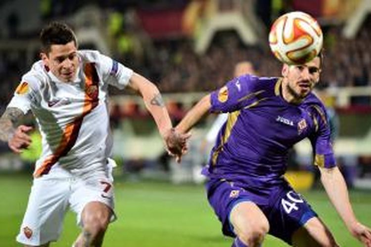 Striker AS Roma, Juan Iturbe (kiri) saat berebut bola dengan bek Fiorentina, Nedad Tomovic, pada leg pertama 16 besar Liga Europa, di Firenze, Kamis (12/3/2015). 