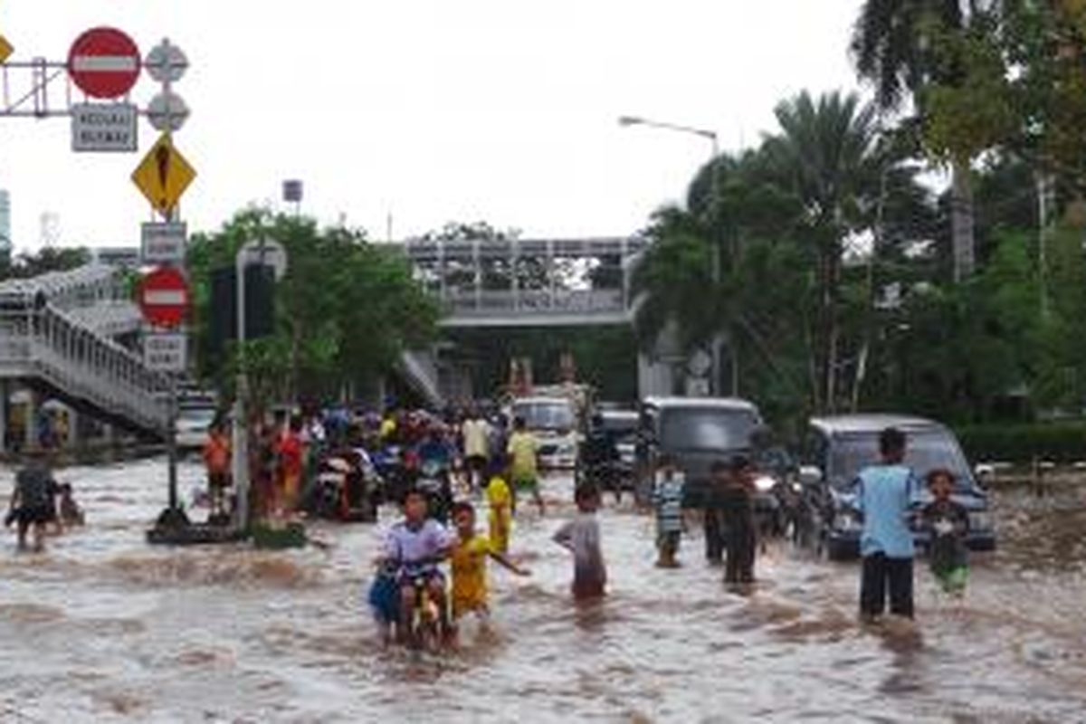 Anak-anak tampak menikmati banjir yang merendam kawasan Green Garden, Jakarta, Selasa (4/2/2014).