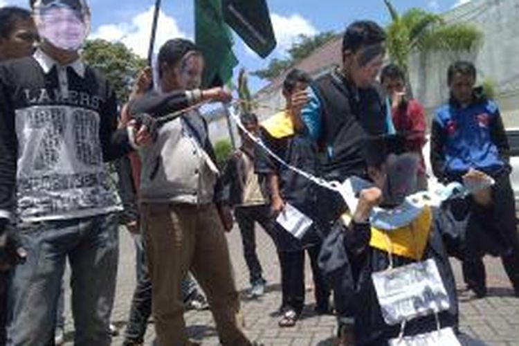 Puluhan mahasiswa berwajah tikus Tong-Tong menggelar demo di depan kantor Kejari Kota Malang, Selasa (12/3/2014). Mereka mendesak Kejari segera tetapkan mantan rektor UIN Malang Imam Suprayogo menjadi tersangkan dalam kasus dugaan korupsi pengadaan lahan kampus UIN II yang ada di Kota Batu.