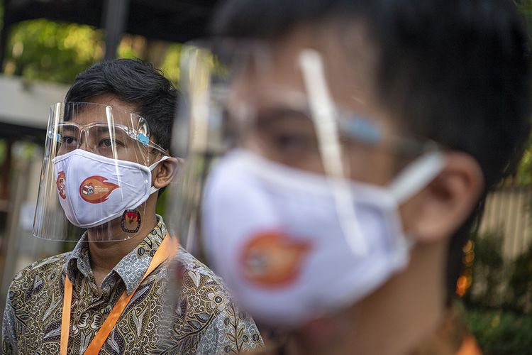 Petugas KPPS mengenakan alat pelindung wajah (face shield) saat simulasi pemungutan suara pemilihan serentak 2020 di Jakarta, Rabu (22/7/2020). Simulasi tersebut digelar untuk memberikan edukasi kepada masyarakat terkait proses pemungutan dan penghitungan suara Pilkada serentak 2020 yang akan dilaksanakan pada 9 Desember 2020 dengan menerapkan protokol kesehatan COVID-19.