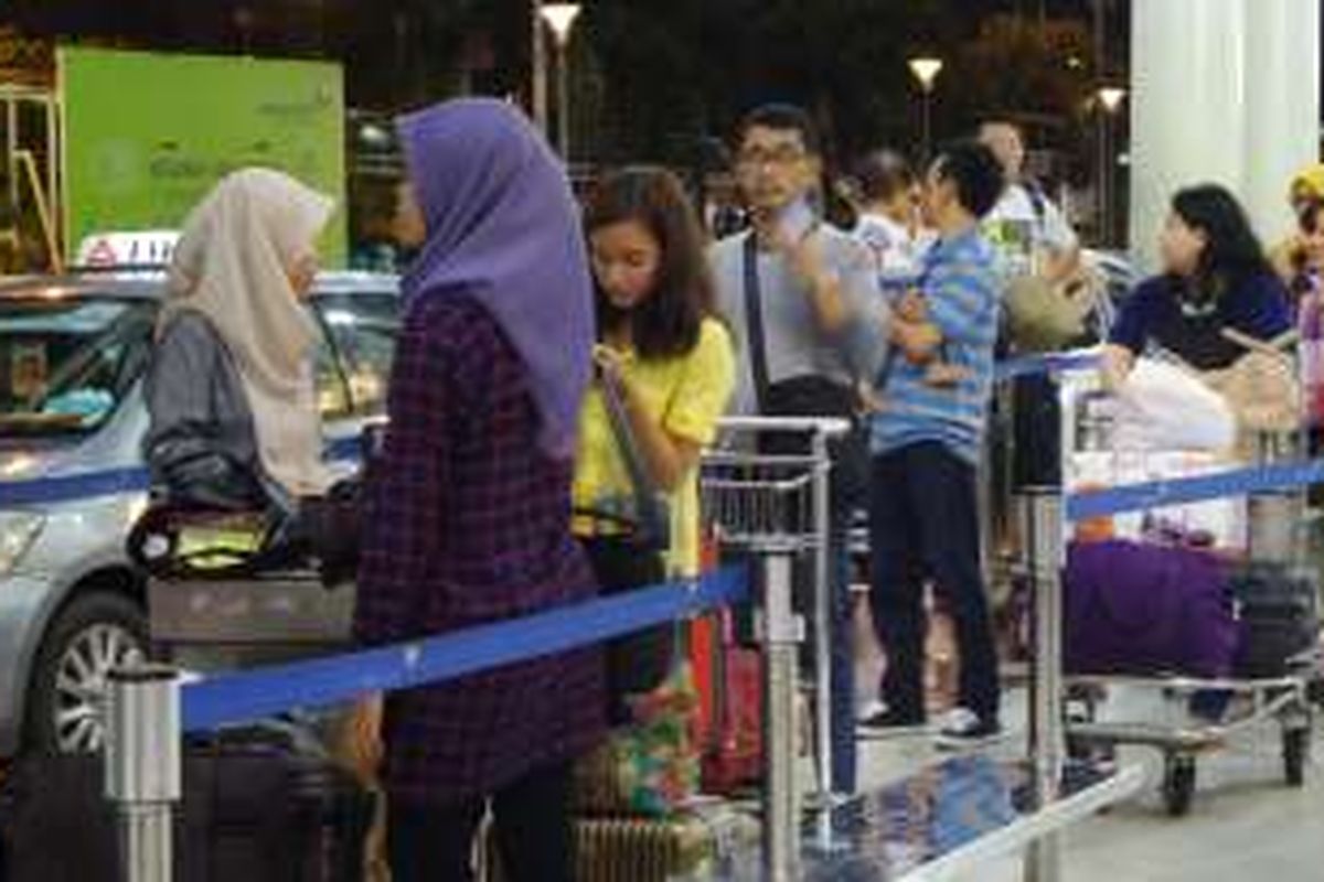 Sejumlah penumpang antre untuk mendapatkan taksi di Terminal 1B Bandara Soekarno-Hatta, Senin (11/7/2016) malam. Manajemen bandara menerapkan sistem FIFO (First In First Out) bagi armada taksi sehingga semua perusahaan dapat kebagian penumpang.