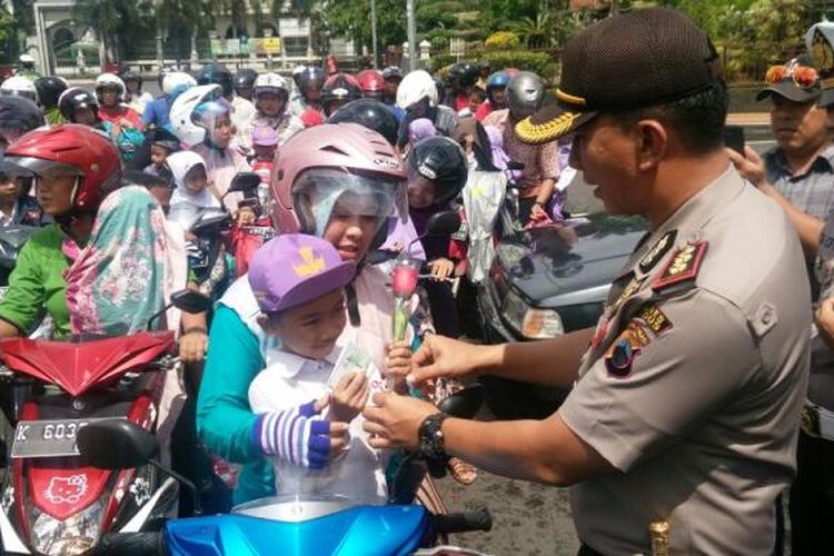 Kapolres Kudus AKBP Andy Rifai membagikan helm dan bunga kepada pengendara di depan Pendopo Pemkab Kudus saat aksi simpatik di hari kasih sayang,  Selasa (14/2/2017) ( Foto Dokumentasi Humas Polres Kudus)  