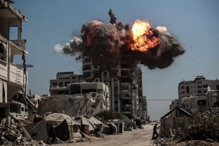 Asap mengepul setelah serangan udara Israel yang menghantam dan menghancurkan beberapa gedung dan menara tinggi di Kota Gaza, pada Minggu (14/9/2025).