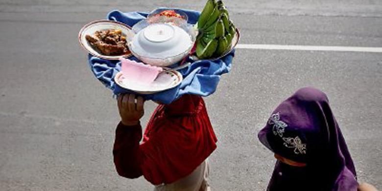 Ibu-ibu membawa antaran makanan di Jalan Raya Payakumbuh-Lintau, Sumatera Barat, Senin (8/7/2013). Rendang menjadi bagian penting di antara sejumlah makanan yang dibawa. Antaran makanan ini dibawa dan dimasak ibu-ibu untuk acara mendoa (berdoa bersama dan siraman rohani) di masjid terdekat untuk menyambut bulan puasa.