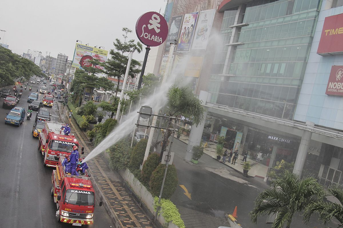 Petugas pemadam kebakaran menyemprotkan cairan disinfektan di jalan Margonda Raya, Depok, Jawa Barat, Senin (23/3/2020).Penyemprotan disinfektan di jalan protokol dan fasilitas umum di kota tersebut guna mencegah penyebaran virus corona atau COVID-19.