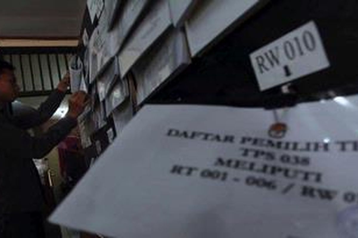 Petugas Kelurahan Kebon Kacang, Jakarta Pusat,  melihat Daftar Pemilih Tetap (DPT) di wilayah kelurahan tersebut, Senin (21/5/2012). Berdasar pleno tingkat kelurahan, sebanyak 18.614 warga dari 42 TPS di Kelurahan Kebon Kacang disahkan untuk mengikuti Pilgub DKI Jakarta.  