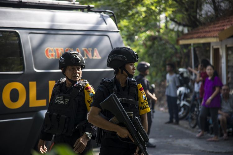 Anggota polisi berjaga di lokasi lokasi ledakan bom di gereja di Surabaya, Minggu (13/5/2018). 