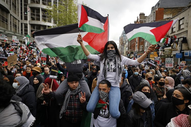 Massa pro-Palestina mengibarkan bendera dan membawa plakat dalam demo mendukung Palestina di luar Kedutaan Besar Israel di London, Inggris, pada Sabtu (15/5/2021).
