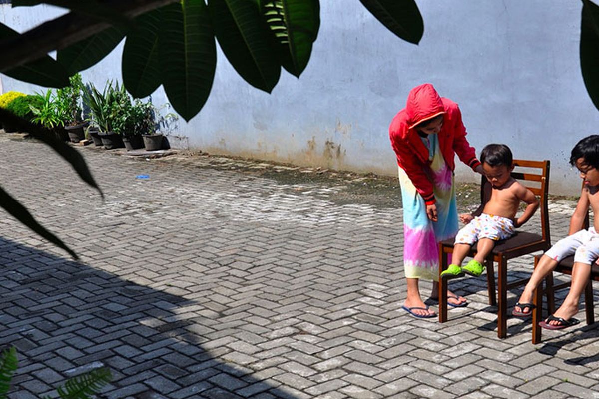 Seorang ibu menjemur kedua anaknya di bawah sinar matahari saat Self Isolation atau tinggal di rumah di Medan, Sumatera Utara, Minggu (22/3/2020). Berjemur diri di bawah matahari di antara pukul 08.00 WIB-11.00 WIB merupakan salah satu upaya yang paling sederhana untuk menjaga kesehatan selama wabah virus COVID-19.