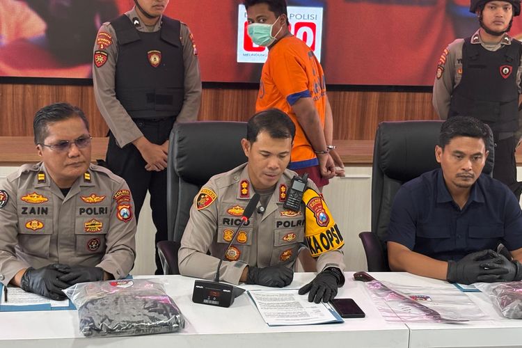 Pelaku DEP mengenakan baju orange dengan tangan diborgol ditunjukkan kepada awak media di Mapolres Probolinggo Kota, Selasa (2/9/2025). Ia merupakan pelaku pembacokan seorang mahasiswa saat pawai budaya di Probolinggo.