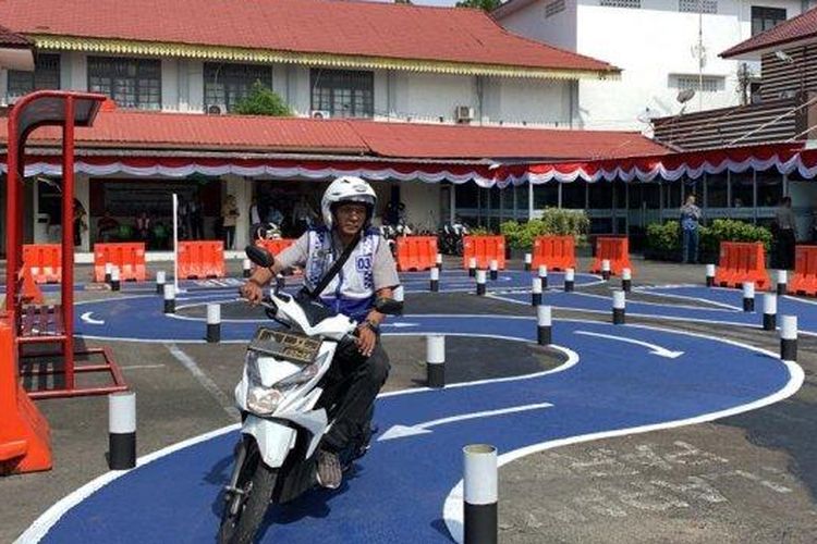 Peserta ujian praktik SIM C sedang mengendarai sepeda motor melintasi jalur S yang telah disediakan oleh petugas di Kantor Sat Lantas Polrestabes Medan di Jalan Adinegoro, Kota Medan, Senin (7/8/2023).  
