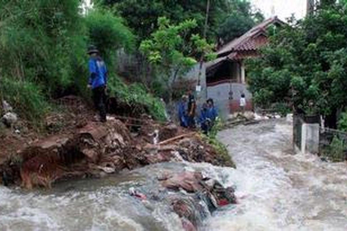 Anggota Satgas Banjir Dinas Bina Marga dan Sumber Daya Air Kota Depok tengah memeriksa tanggul Kali Laya di Kelurahan Tugu, Cimanggis, Depok, Selasa (13/11/2012) yang jebol. Tanggul kali jebol akibat tak kuasa menahan debit air sehingga air tumpah membanjiri puluhan rumah di Perumahan Bukit Cengkeh 2. Tidak ada korban jiwa dalam peristiwa yang berlangsung sekitar pukul 01.00 dini hari ini.