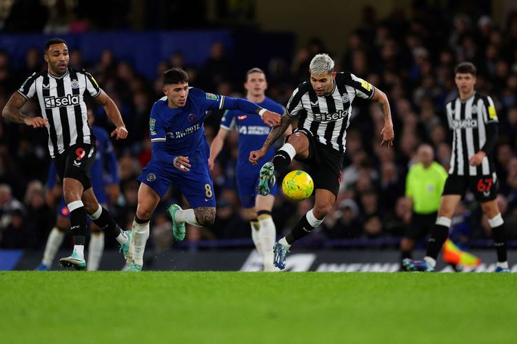 Gelandang Chelsea Enzo Fernandez (biru/kiri) berebut bola dengan gelandang Newcastle United Bruno Guimaraes saat pertandingan perempat final Piala Liga Inggris antara Chelsea vs Newcastle United di Stamford Bridge di London pada 19 Desember 2023.