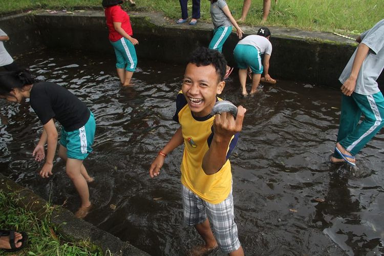 Pengunjung sedang merasakan bagaimana menangkap ikan di kolam di Desa Wisata Pentingsari.