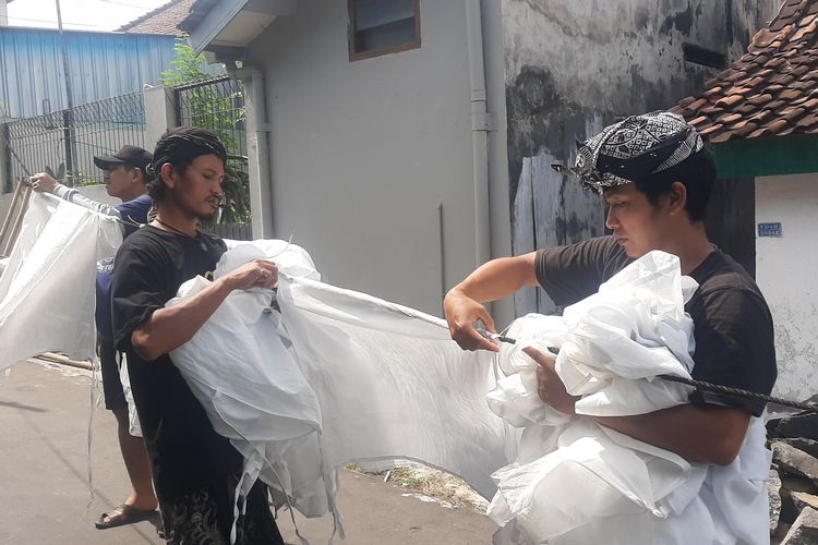 Warga Suku Osing Banyuwangi melepaskan kain mori yang telah dicuci dan kering dalam ritual adat Resik Lawon, di Lingkungan Cungking, Kecamatan/Kabupaten Banyuwangi, Jawa Timur, Kamis (18/3/2022).