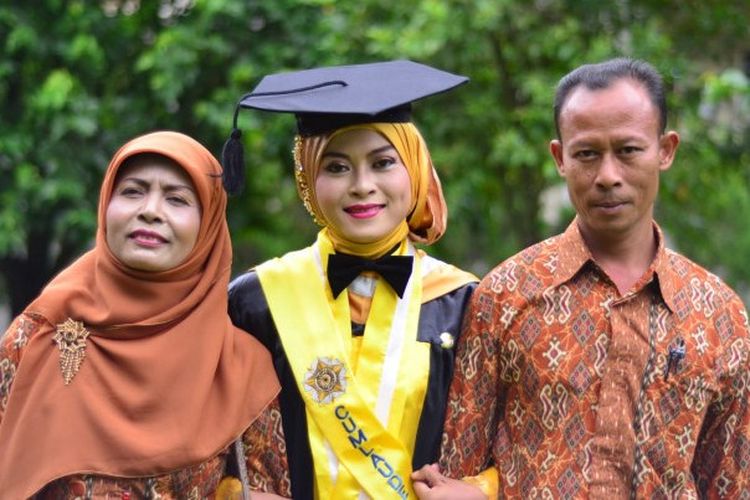 Sawitri diapit kedua orangtuanya usai wisuda di UGM.